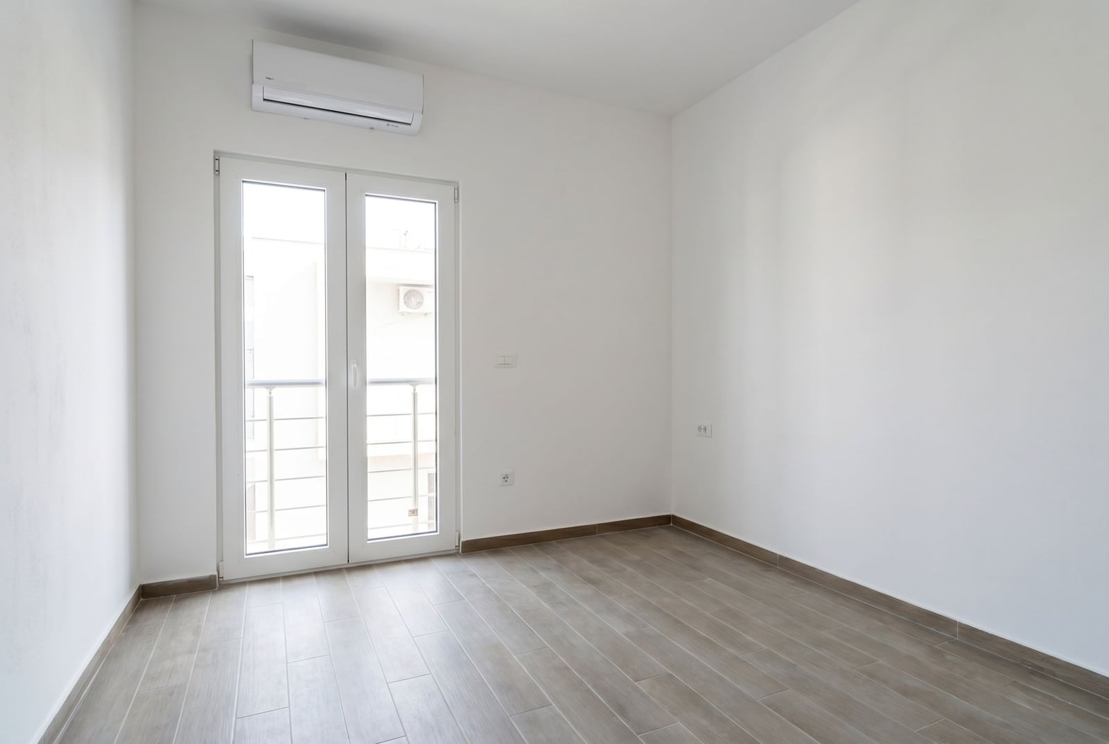 Bright empty bedroom with air conditioning and access to the balcony in an apartment, Herceg Novi, Montenegro.