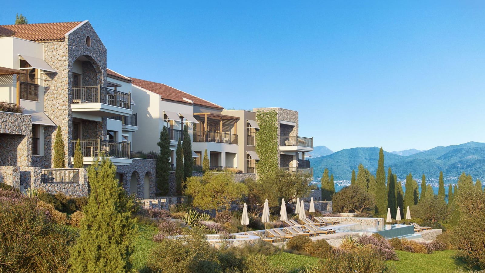 Luxury residential complex in Luštica, Montenegro: stone facade finishing, terraces, and a pool with mountain and sea views.