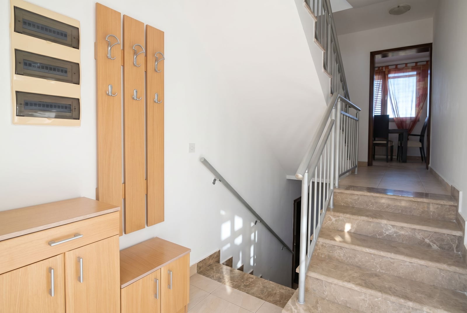 Hallway with wooden furniture and a marble staircase in a house, Baošići, Montenegro.