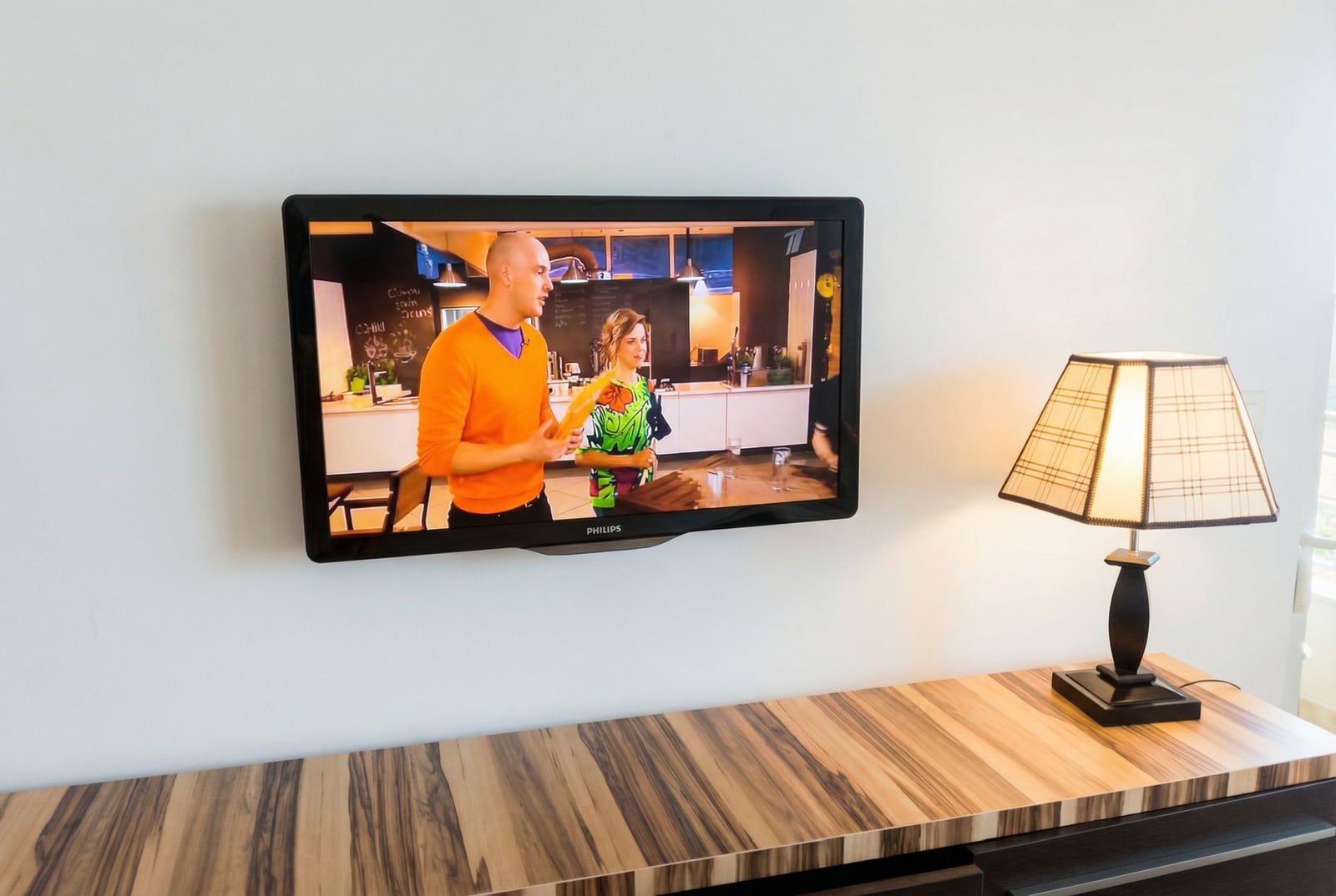 Телевизор Philips на стене и настольная лампа в гостиной квартиры в Петроваце, Черногория.