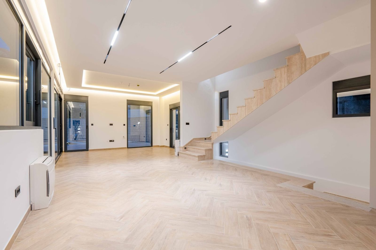 Salon spacieux avec escalier et parquet clair dans une villa moderne, Kamenovo, Monténégro.
