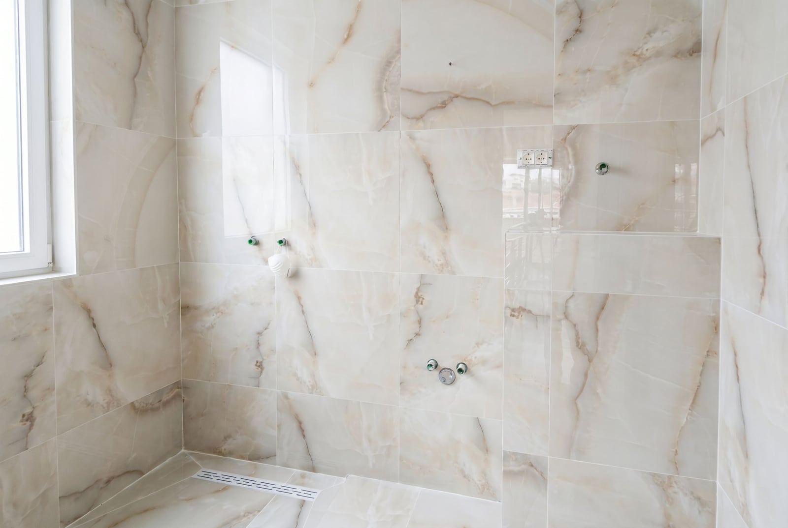 Bathroom with light marble finishes in an apartment, Đenovići, Montenegro. Built-in drain installed.