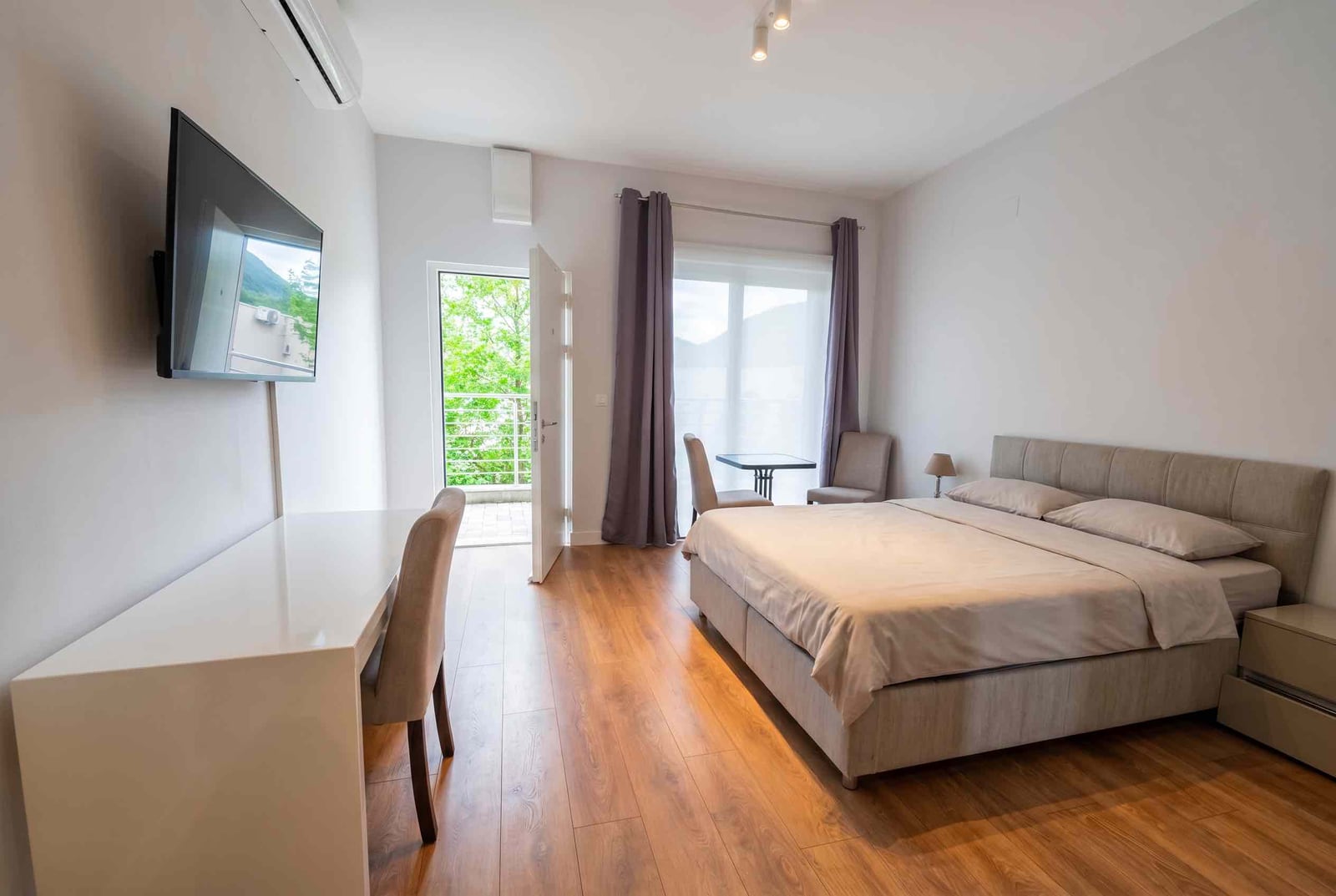 Modern bedroom with a double bed and balcony access in an apartment, Kavač, Montenegro.