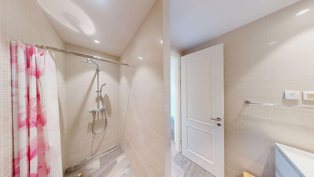 Modern bathroom with a shower cabin in an apartment, Luštica, Montenegro: light-colored tiles and high-quality finishes.