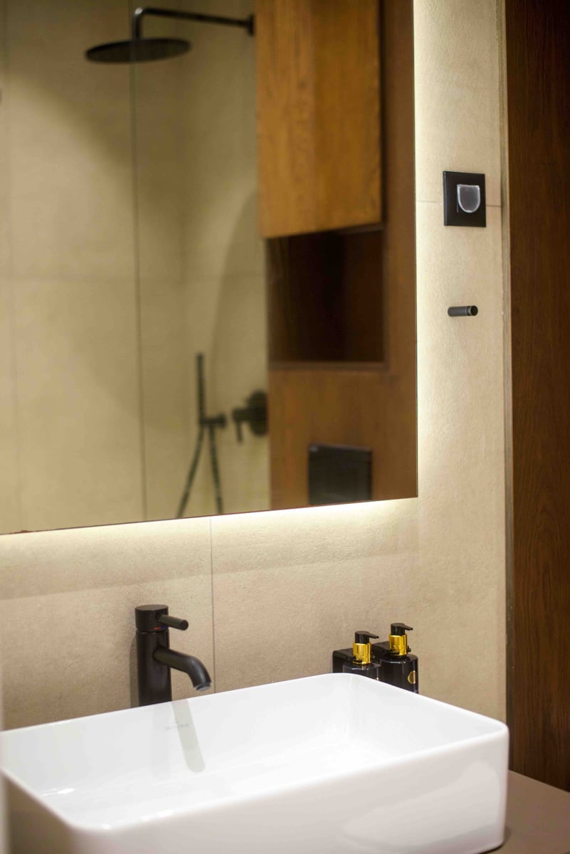 Modern bathroom with a countertop sink and illuminated mirror in an apartment, Bečići, Montenegro.