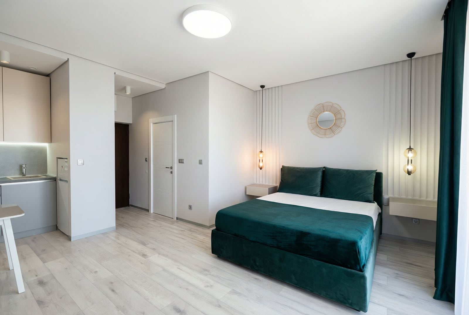 Modernes Schlafzimmer mit smaragdgrünem Bett und Küche in einer Wohnung in Bečići, Montenegro: stilvolles Interieur und heller Boden.