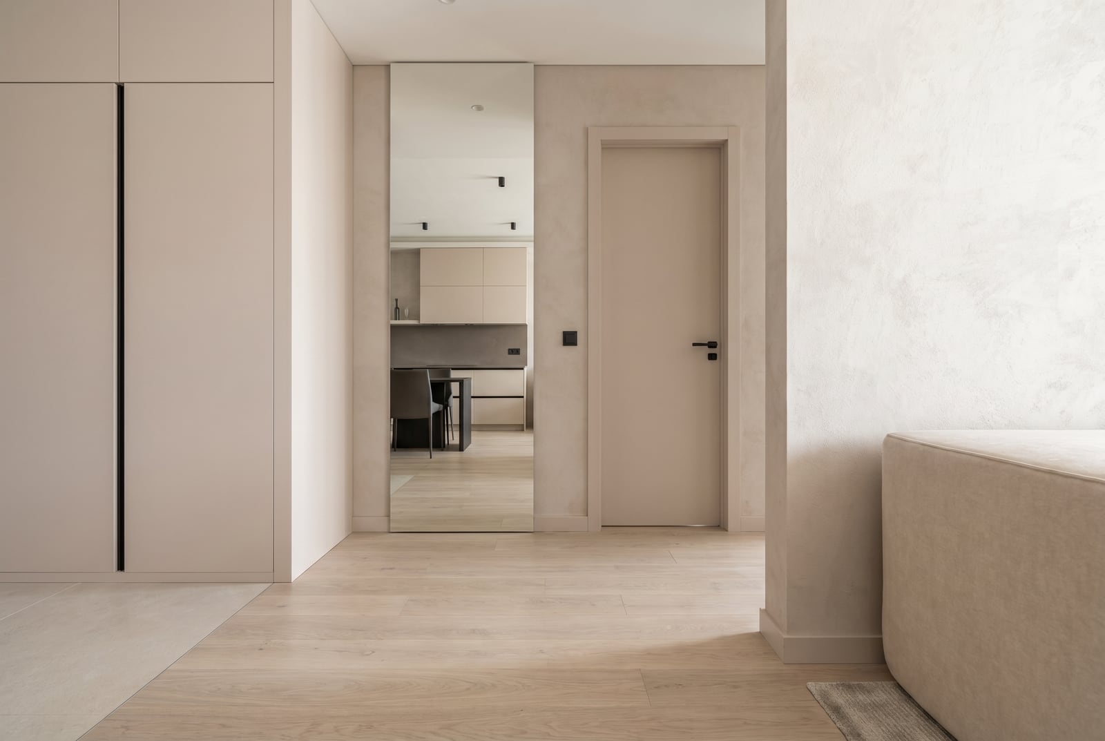 Modern living room interior in light tones with a mirror and built-in wardrobe in the Tivat residential complex, Montenegro.
