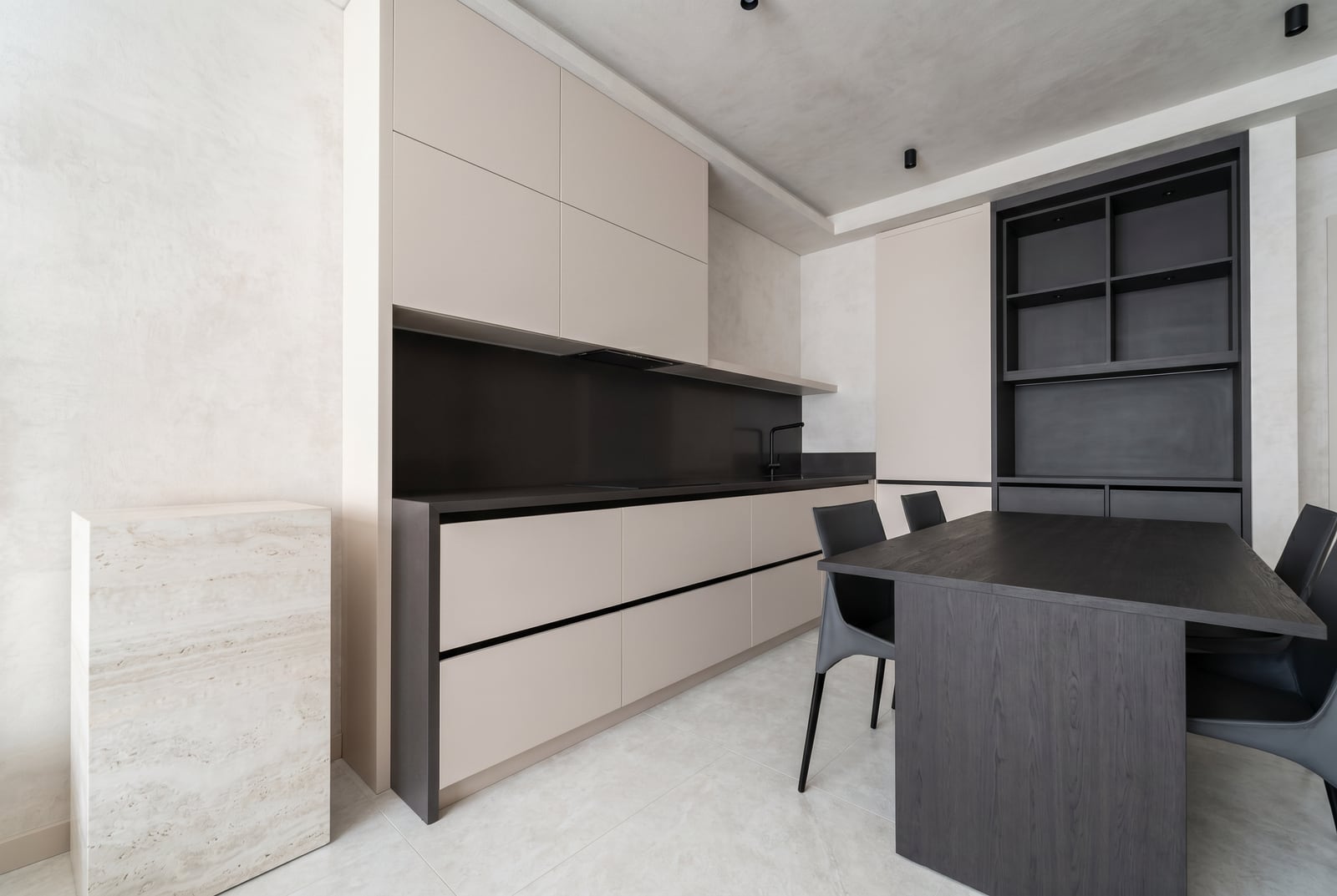 Modern minimalist kitchen with black furniture and dining area in an apartment, city of Tivat, Montenegro.