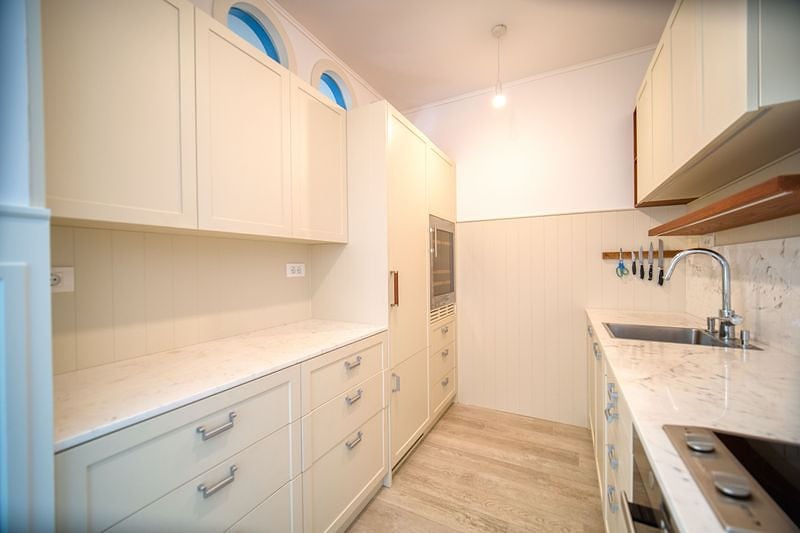 Modern bright kitchen with marble countertop in an apartment in Luštica, Montenegro: built-in appliances and design.
