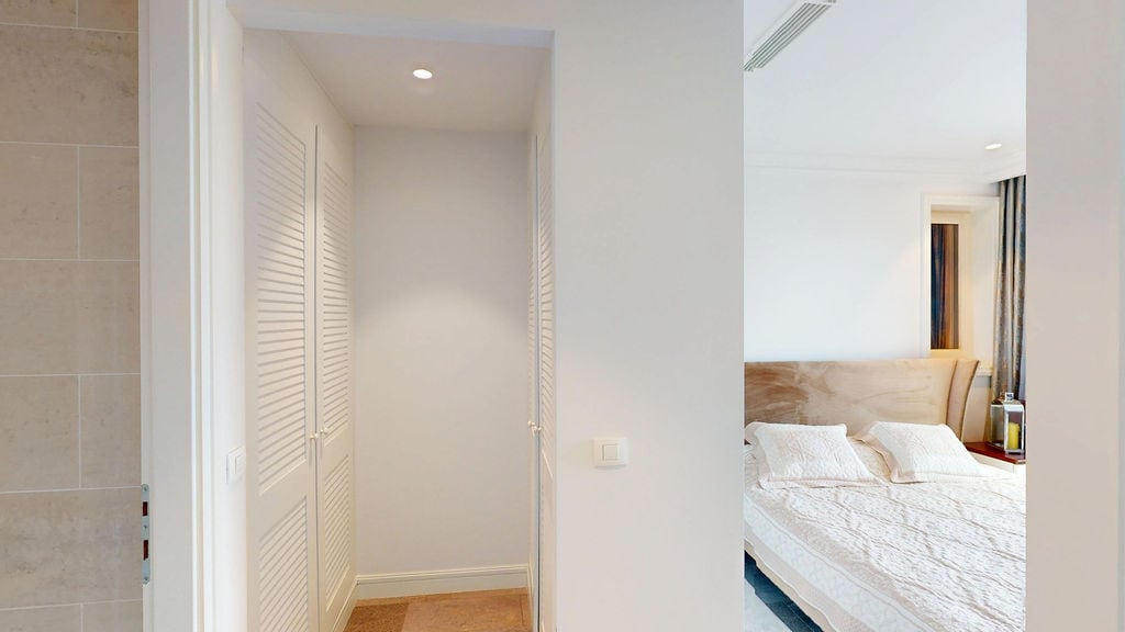 Bright bedroom with a double bed and built-in wardrobe in a modern apartment, Luštica, Montenegro.