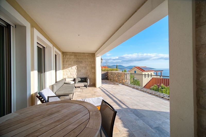 Spacious terrace with furniture and sea view in a residential complex, Luštica, Montenegro. Natural stone finish.