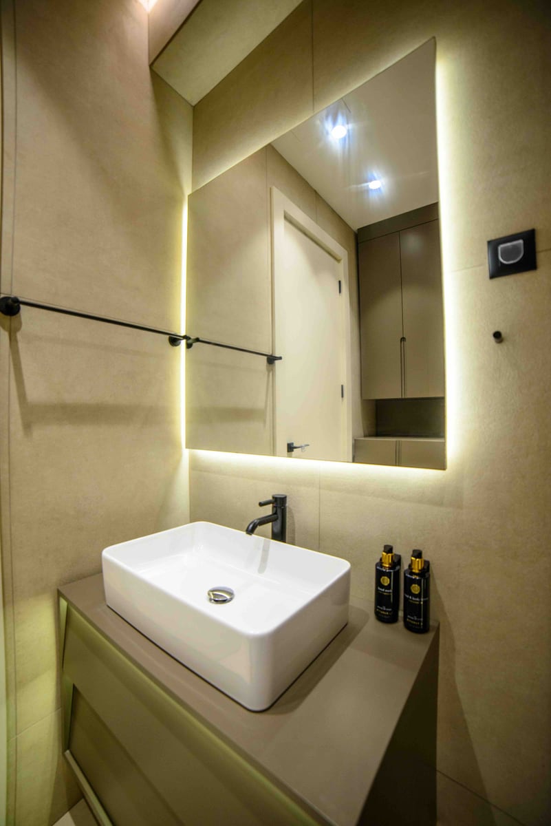 Modern bathroom in an apartment, Bečići, Montenegro: countertop sink, illuminated mirror, and stylish finishes.