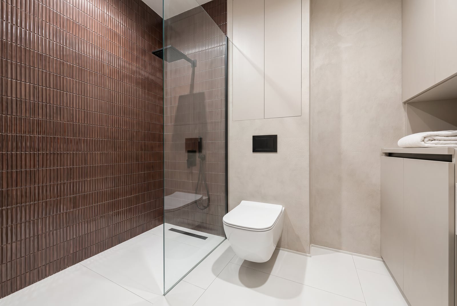 Modern bathroom in an apartment, Tivat, Montenegro: shower cabin, brown tiles, and plumbing fixtures.
