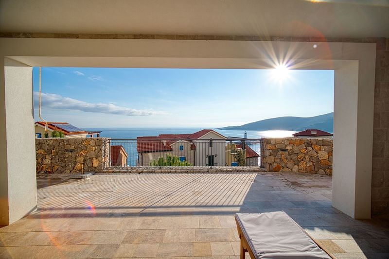 Spacious terrace with sea view in the Luštica residential complex, Montenegro: stone finish and sun lounger.