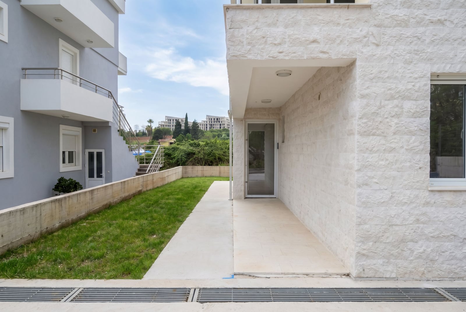 Modern apartment with a terrace and green lawn in Herceg Novi, Montenegro: view of the light stone building facade.