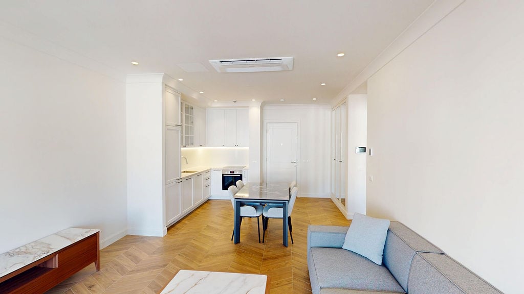 Modern living room with kitchen in an apartment, Luštica, Montenegro: bright interior, herringbone parquet flooring, and stylish furniture.