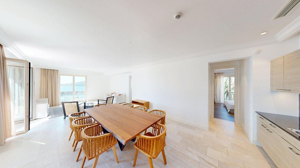 Bright living room with a dining area and sea view in an apartment, Luštica, Montenegro: modern interior and furniture.