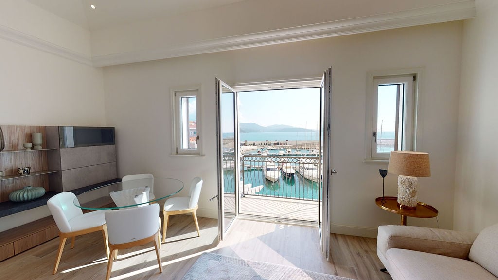 Living room with a view of the marina and yachts in the elite residential complex Luštica, Montenegro: modern furniture, bright interior, balcony.