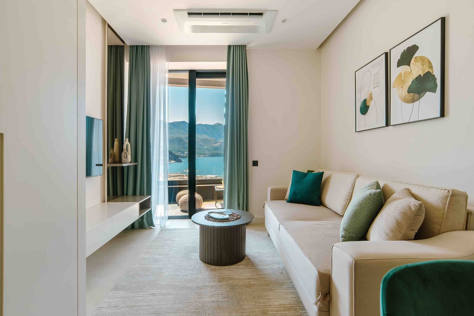 Modern living room in an apartment, Bečići, Montenegro: bright interior, sofa, sea and mountain view from the terrace.
