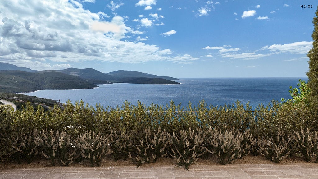 Panoramic view of the Adriatic Sea and mountains from the terrace of an apartment in Luštica, Montenegro, with green vegetation.
