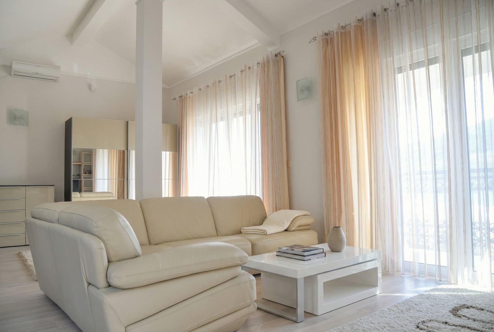 Bright living room with a leather sofa in a house in Herceg Novi, Montenegro: modern interior with panoramic windows.