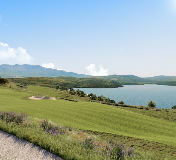 Panoramic view of the golf course and sea at the Luštica Bay residential complex, Montenegro: green hills and a sea bay.