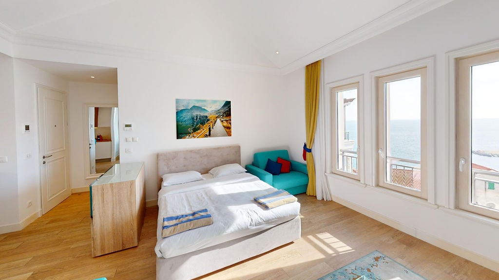 Bright bedroom with a double bed and sea view in an apartment, Krašići, Montenegro. Modern interior.