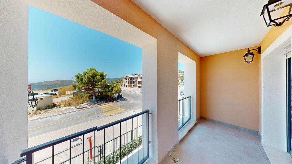 Spacious balcony with street and landscape views in the Lustica Bay residential complex, Montenegro. Modern finishes and railings.