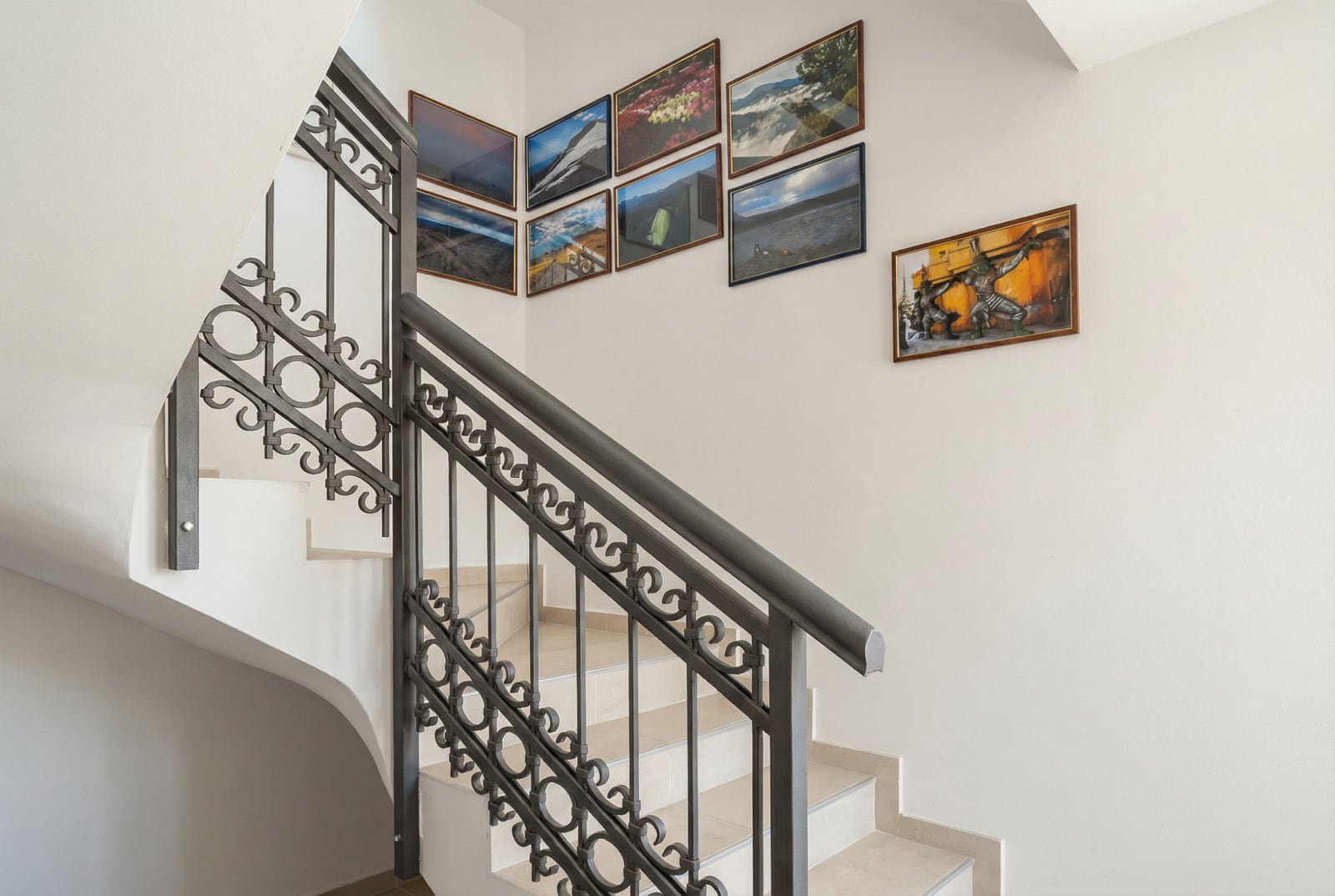 Staircase with wrought-iron railings and paintings on the wall in a house, Herceg Novi, Montenegro. House interior No. 2624.