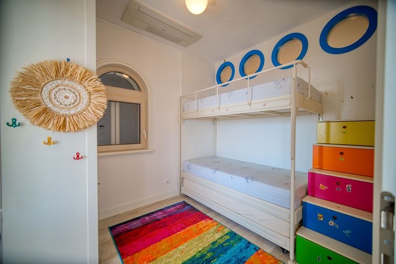 Children's bedroom with a bunk bed and bright furniture in an apartment in Luštica, Montenegro.