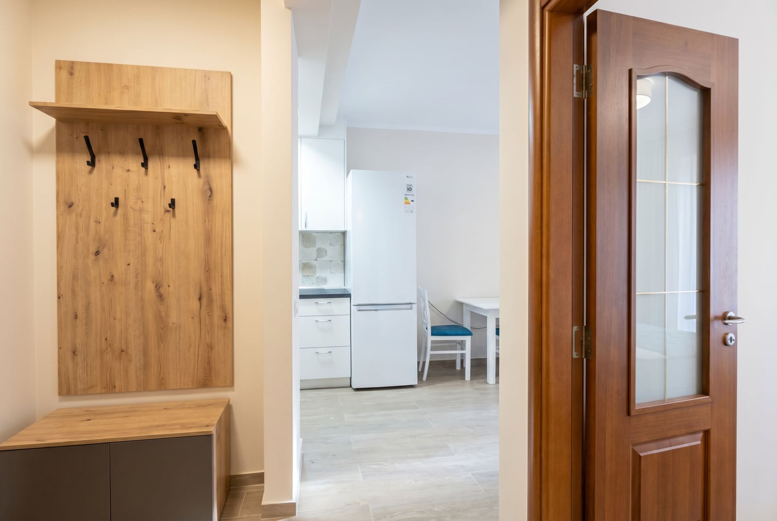 Hallway with a wooden coat rack and a view of the bright kitchen in an apartment, Herceg Novi, Montenegro.