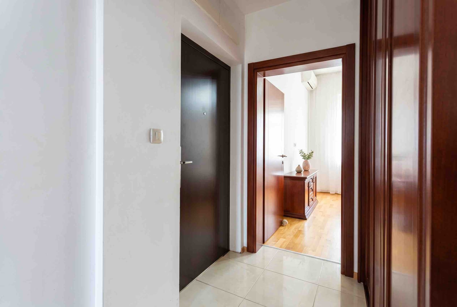 Bright hallway with tiled floor and wooden doors in an apartment, Bečići, Montenegro.