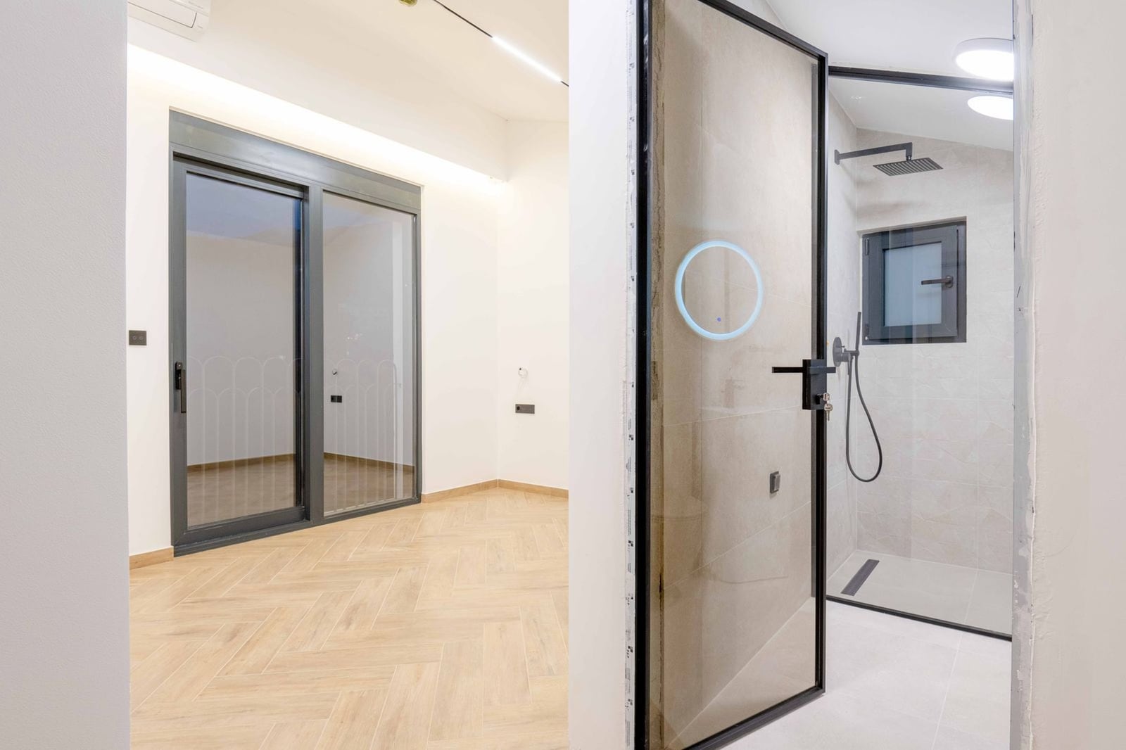 Chambre moderne avec baie vitrée panoramique et salle de bain dans une nouvelle villa, Kamenovo, Monténégro. Finition effet bois.