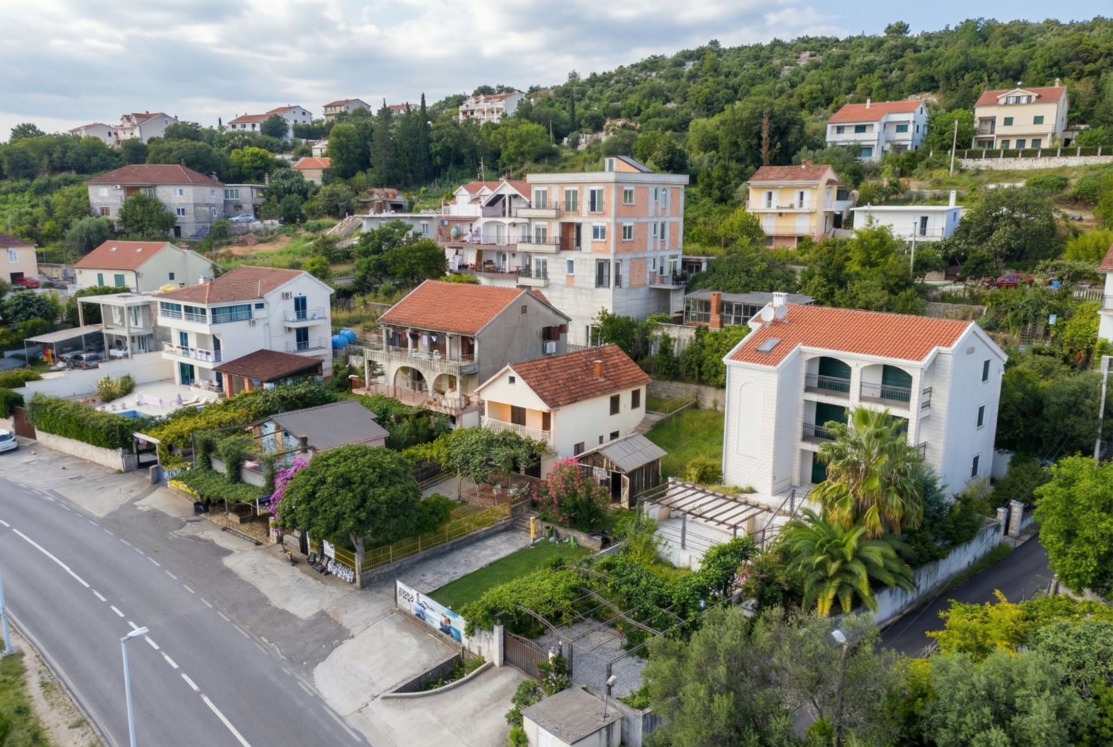 Aerial view of private houses with tiled roofs and green gardens in Herceg Novi, Montenegro.