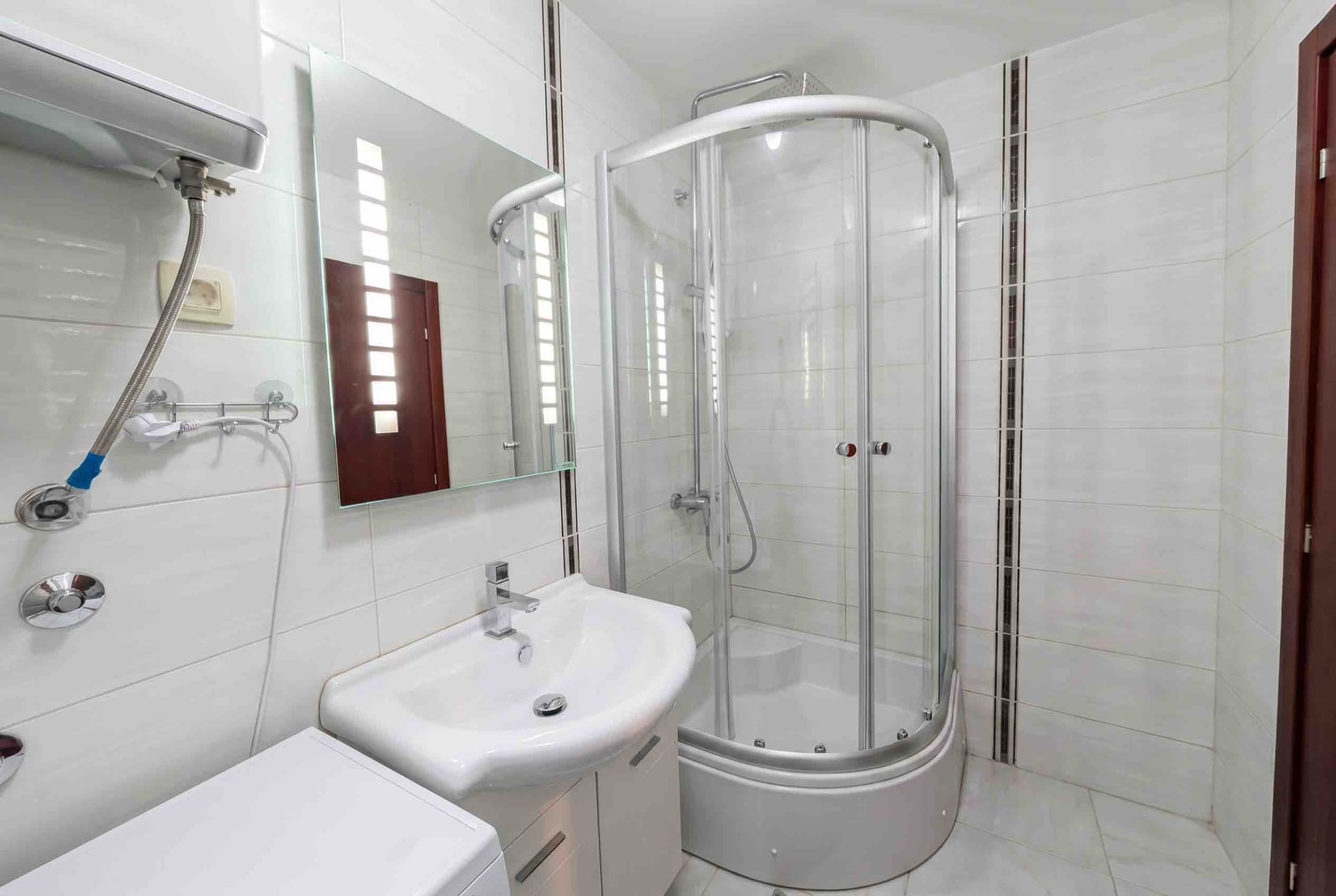 Bright bathroom with a shower cabin and modern finishes in an apartment in Bečići, Montenegro.