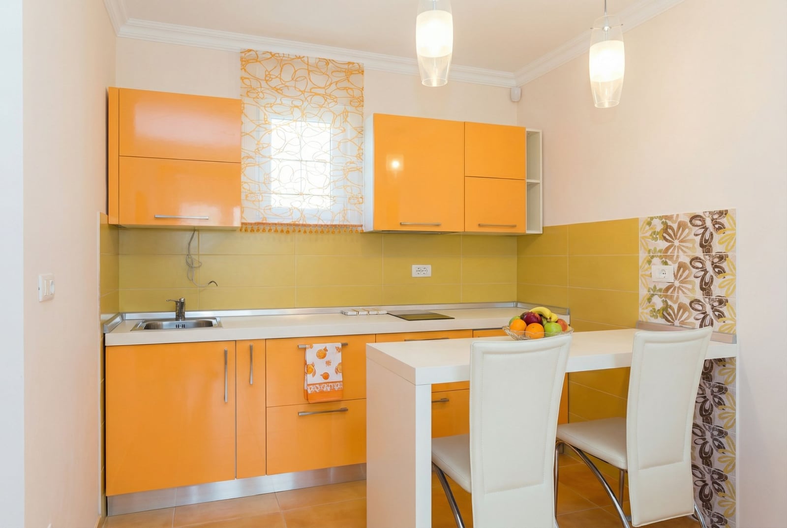 Bright kitchen with an orange cabinet set and a bar counter in a house for sale, Herceg Novi, Montenegro.