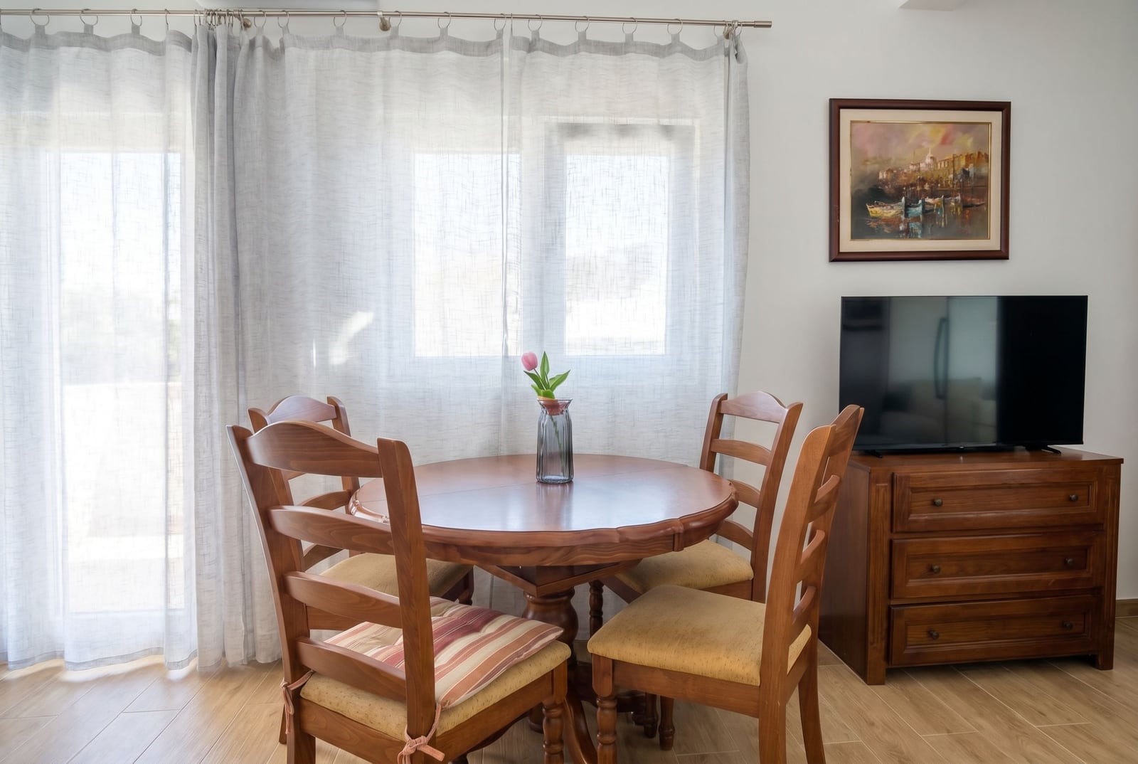 Cozy living room with a wooden dining table and TV area in an apartment, Herceg Novi, Montenegro.